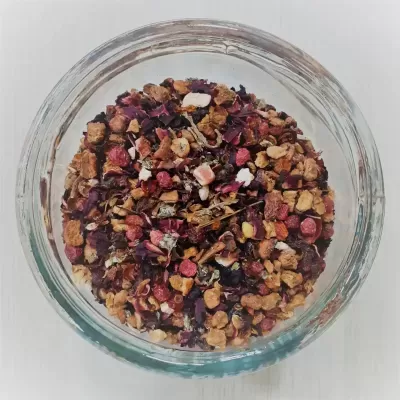 Recipiente de vidro com mistura seca de chá de ervas e frutas coloridas