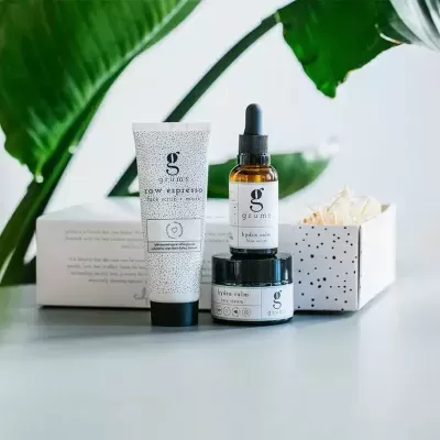 Conjunto de produtos para pele da marca grams com 3 embalagens com padrões pontilhados e caixas brancas