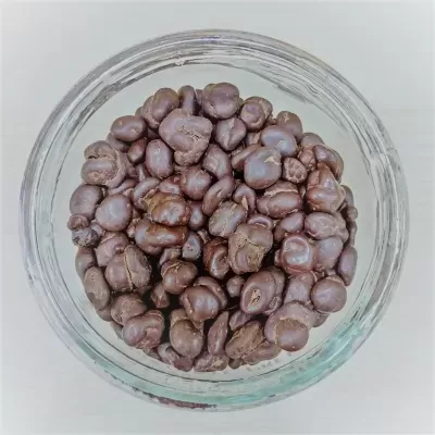 Chávena de vidro com amendoins cobertos por chocolate escuro