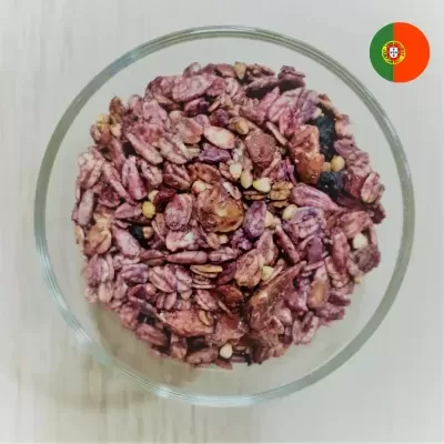 Tigela de vidro com granola roxa e frutos secos
