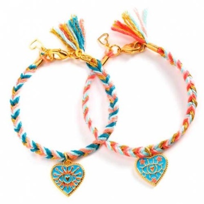 Duas pulseiras coloridas trançadas com pendente de coração azul e elementos dourados
