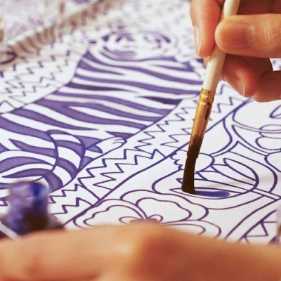 Pessoa a pintar desenho de zebra com pincel e tinta azul