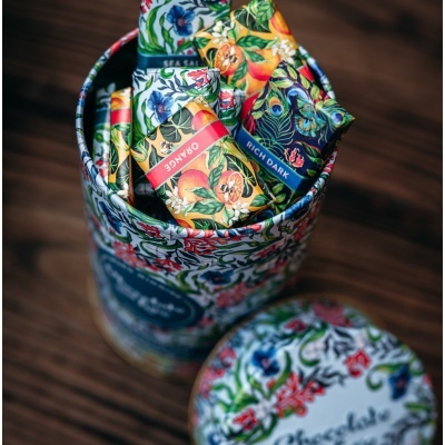 Lata redonda decorativa com barras de chocolate embaladas com rótulos coloridos