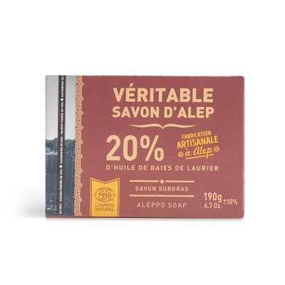 Sabonete em barra embalado em papel vermelho com texto dourado e selo COSMOS NATURAL