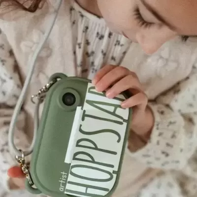 Criança a segurar carteira verde com etiqueta HOPPSIA