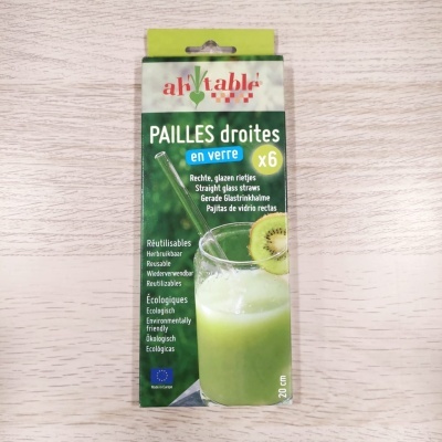 Embalagem verde com palhinhas de vidro retas reutilizáveis e bebida verde com kiwi