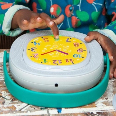 Relógio educativo colorido com mostrador amarelo e suporte verde.