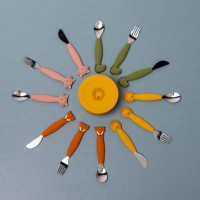 Conjunto colorido de talheres infantis com cabos em forma de animais e um prato amarelo ao centro