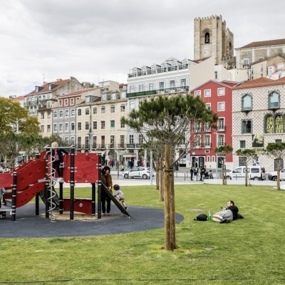 Childrens playground with red slides in park near historic city buildings