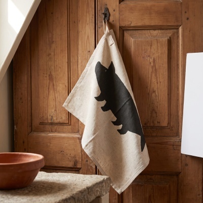 Cotton kitchen towel with black silhouette hanging on wooden door