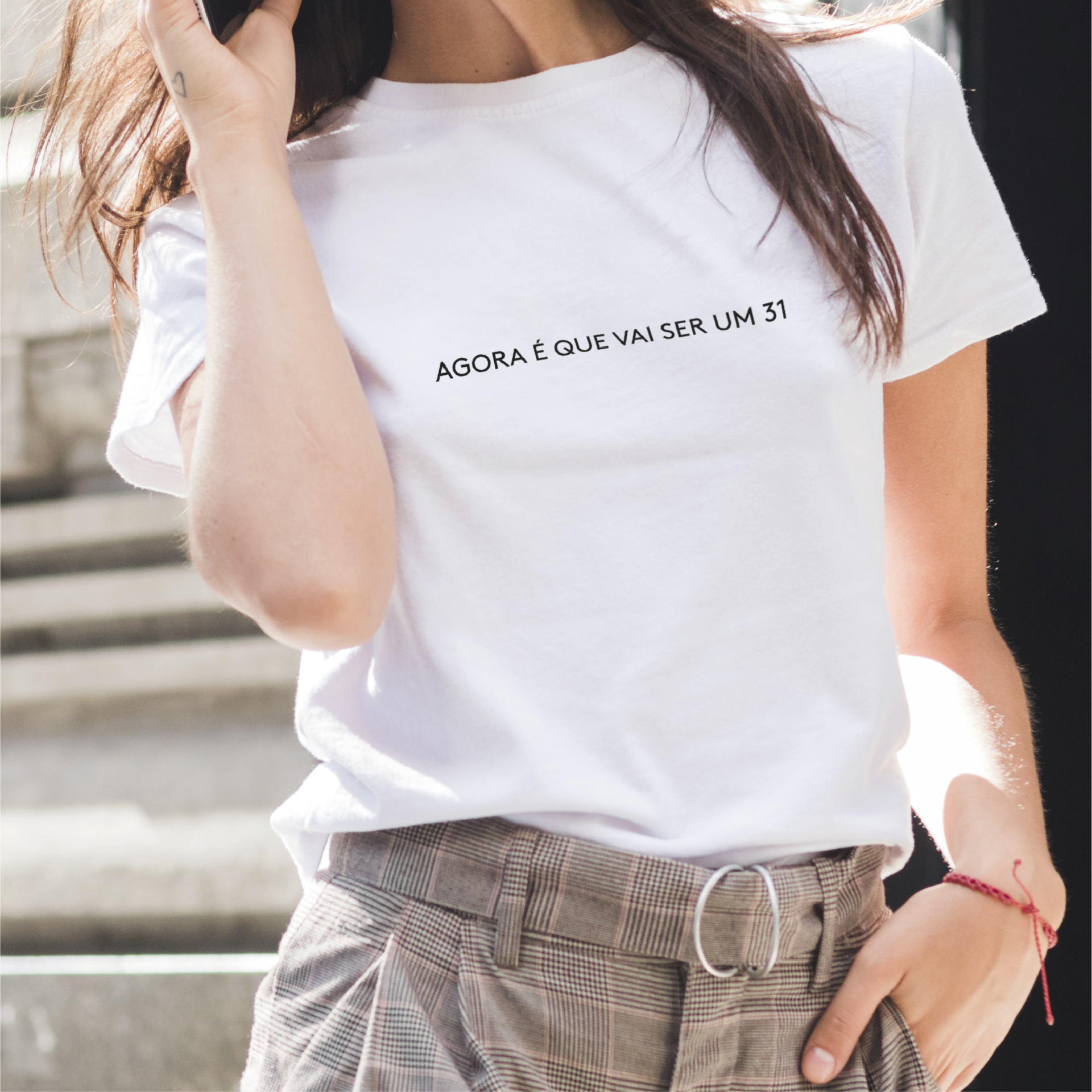 T-shirt “Agora é que vai ser um 31” T-shirt branca com texto preto e calças xadrez castanho claro com cinto
