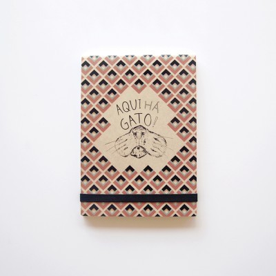 Caderno com capa geométrica castanha e texto 'AQUI HÁ GATO!'