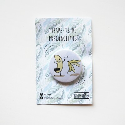 Botton redondo com ilustração divertida de banana e texto em fundo branco com padrão de folhas