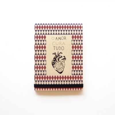 Caderno com capa decorada e texto O AMOR CURA TUDO