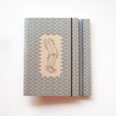 Caderno com padrão geométrico azul e branco e texto em português no centro