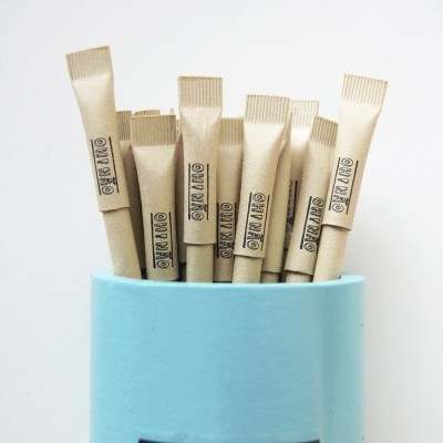 Palhinhas de papel castanho com texto ON A MO num pacote azul