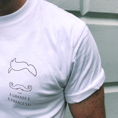 Camisola branca com desenhos de bigodes e texto em preto