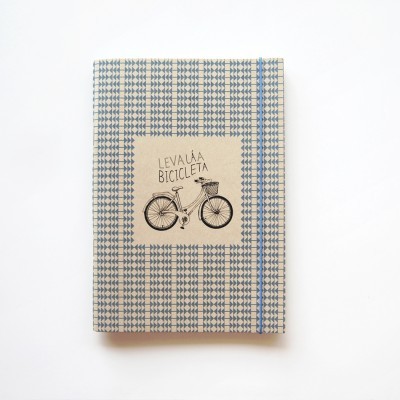 Caderno xadrez azul e branco com elástico e desenho de bicicleta na capa