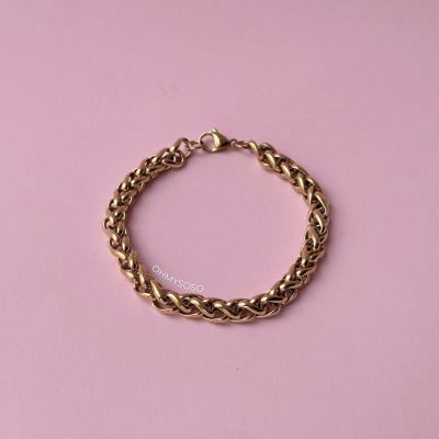 Pulseira dourada entrelaçada sobre fundo rosa com marca OHMYSOSO