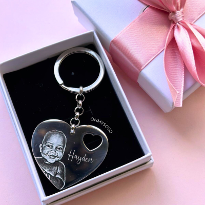 Chaveiro metálico prateado em forma de coração com imagem de bebé e nome Hayden numa caixa branca com fita rosa