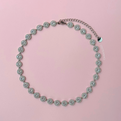 Colar de pedras brilhantes redondas em corrente prateada sobre fundo rosa