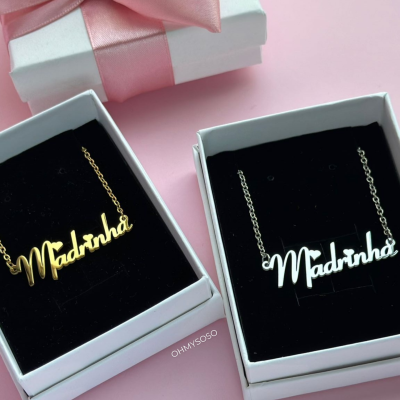 Dois colares Madrinha em caixas com interior preto sobre fundo rosa e caixa de presente com laço rosa