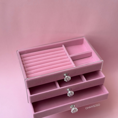 Caixa de joias cor-de-rosa em veludo com três gavetas e puxadores transparentes