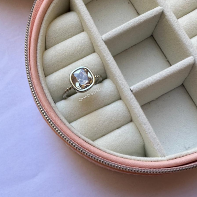Caixa de joias rosa claro com anel prateado com pedra translúcida