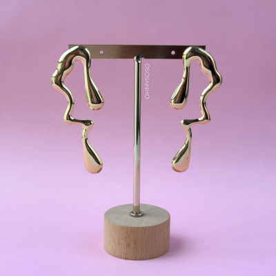 Brincos dourados abstratos em suporte de madeira