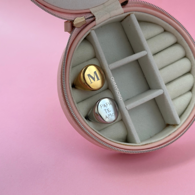 Caixa de joias cor-de-rosa com dois anéis gravados dentro