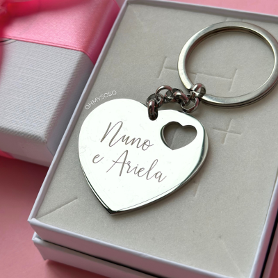 Chaveiro coração metálico com nomes gravados dentro de caixa branca e fita rosa