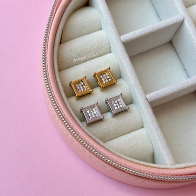 Brincos quadrados dourados e prateados em caixa de veludo creme com zíper rosa