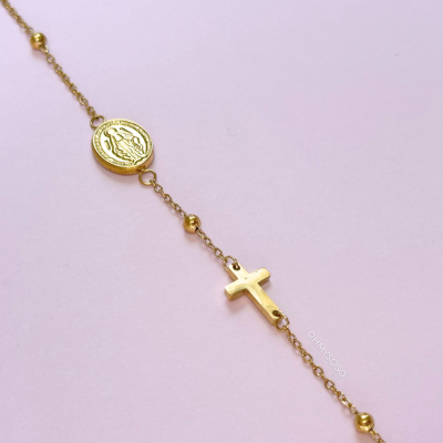 Pulseira dourada com medalha redonda e cruz