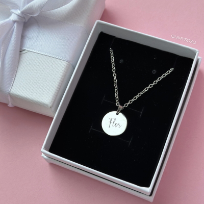 Colar prateado com pendente redondo gravado 'Flor' em caixa branca com interior preto e caixa de presente branca com fita