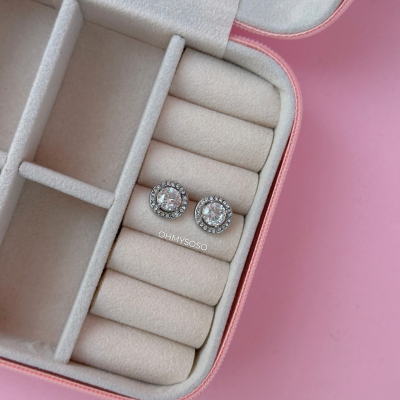 Brincos redondos com pedras em caixa de veludo rosa e bege sobre fundo rosa