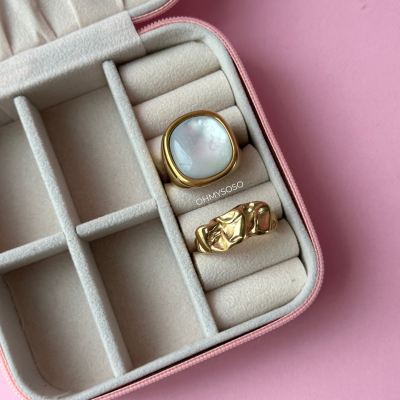 Duas anéis em caixa de veludo bege com borda rosa