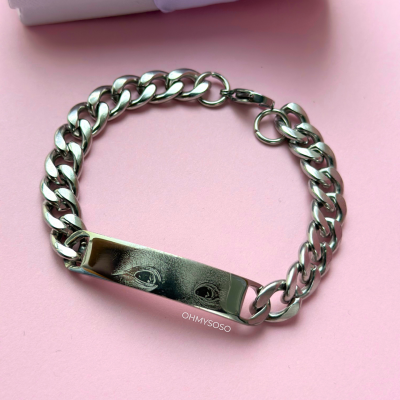 Pulseira prateada com elos grossos e placa com olhos gravados