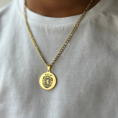 Colar dourado com pendente do Sporting Clube de Portugal sobre t-shirt branca