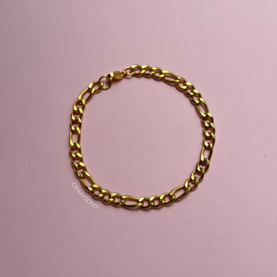 Pulseira dourada de elos ovais e redondos sobre fundo cor-de-rosa