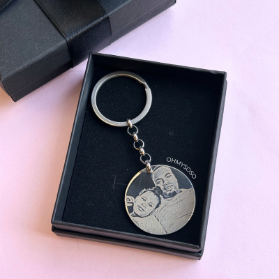 Chaveiro metálico redondo gravado com imagem dentro de caixa preta com tampa e laço preto