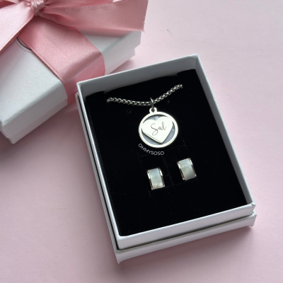 Conjunto de colar e brincos prateados em caixa com fita rosa