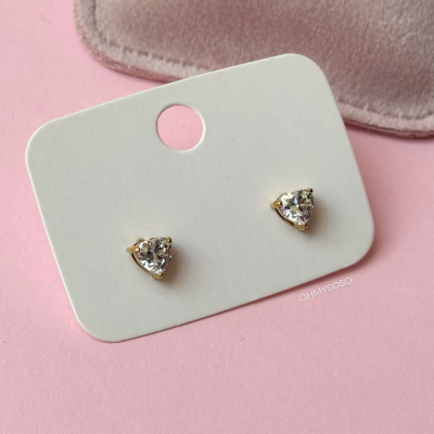 Brincos pequenos triangulares com pedra cristal em base dourada num cartão branco