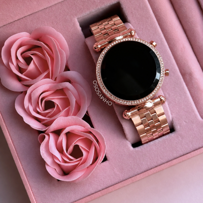Relógio inteligente rosa dourado em caixa almofadada rosa com flores e texto OHMYSOSO.