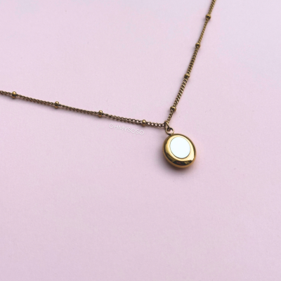 Colar dourado com pendente oval e corrente com pequenas esferas