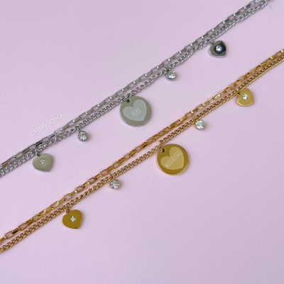 Dois colares com pendentes prateado e dourado sobre fundo rosa