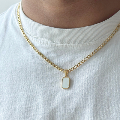 Colar dourado com pendente branco usado com t-shirt branca