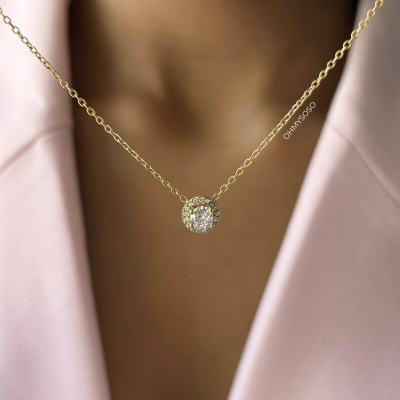 Colar dourado com pendente redondo com pedras brilhantes usado com vestido rosa claro