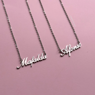 Dois colares com nomes Mafalda e Afonso em letras cursivas em metal prateado sobre fundo rosa