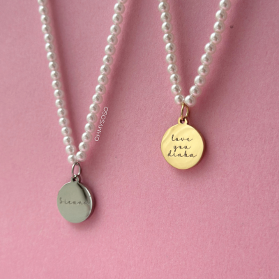 Dois colares de pérolas com pendentes redondos em fundo rosa.