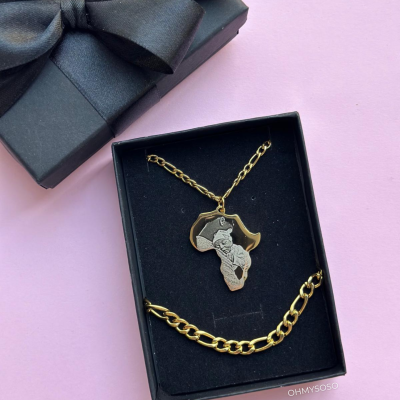 Conjunto de joias douradas numa caixa preta com laço sobre fundo rosa